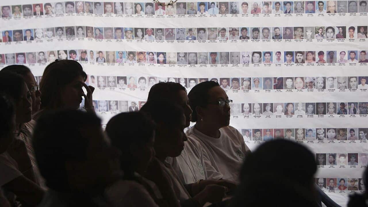 Attendees gather in front of photographs of missing after Nepal conflict.