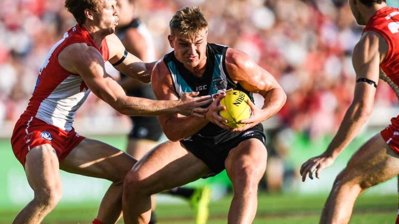 Ollie Wines of the Power competes for possession against Sydney.