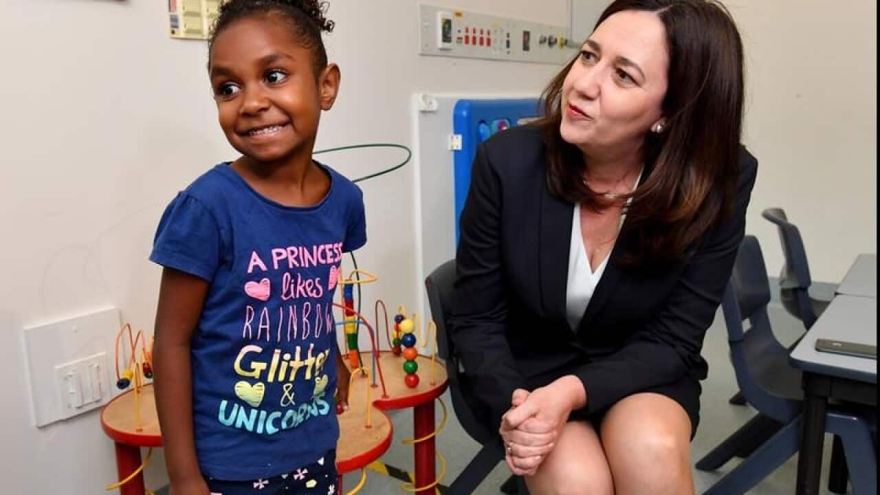 Annastacia Palaszczuk (r) talking to a child at Townsville Hospital.