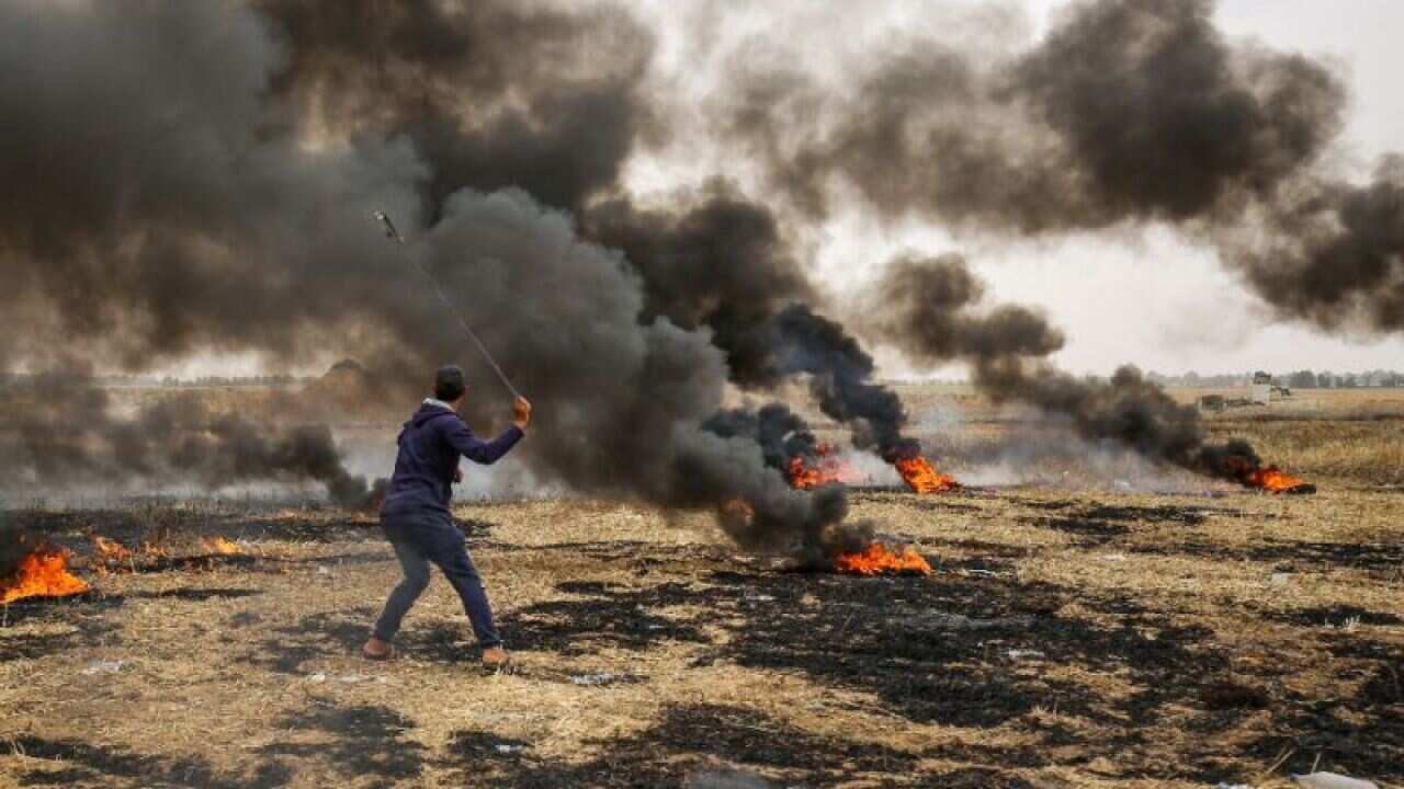 A Palestinian protester uses a sling to hurl stones towards Israeli forces during clashes along the border of the Gaza Strip on May 4, 2018