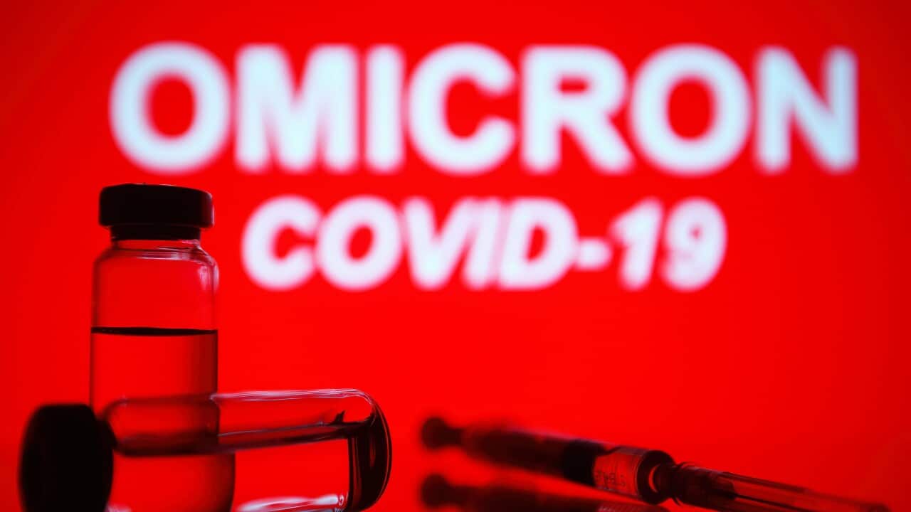 In this photo illustration, a medical syringe and two vials are seen in front of the text Omicron COVID-19 in the background. (Photo by Pavlo Gonchar / SOPA Images/Sipa USA)