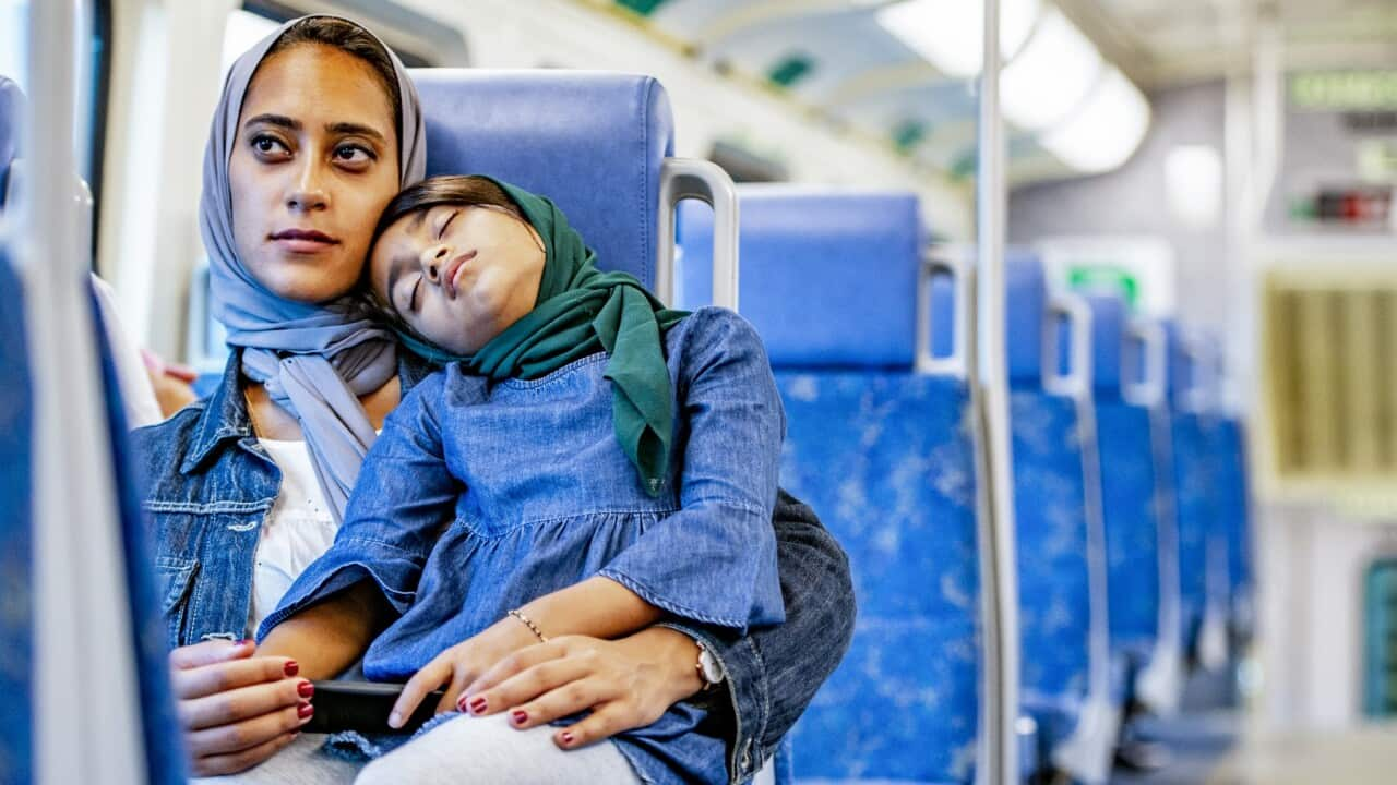 Mother and child sleeping on a train