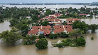 An aerial view shows residential areas surrounded by flood waters