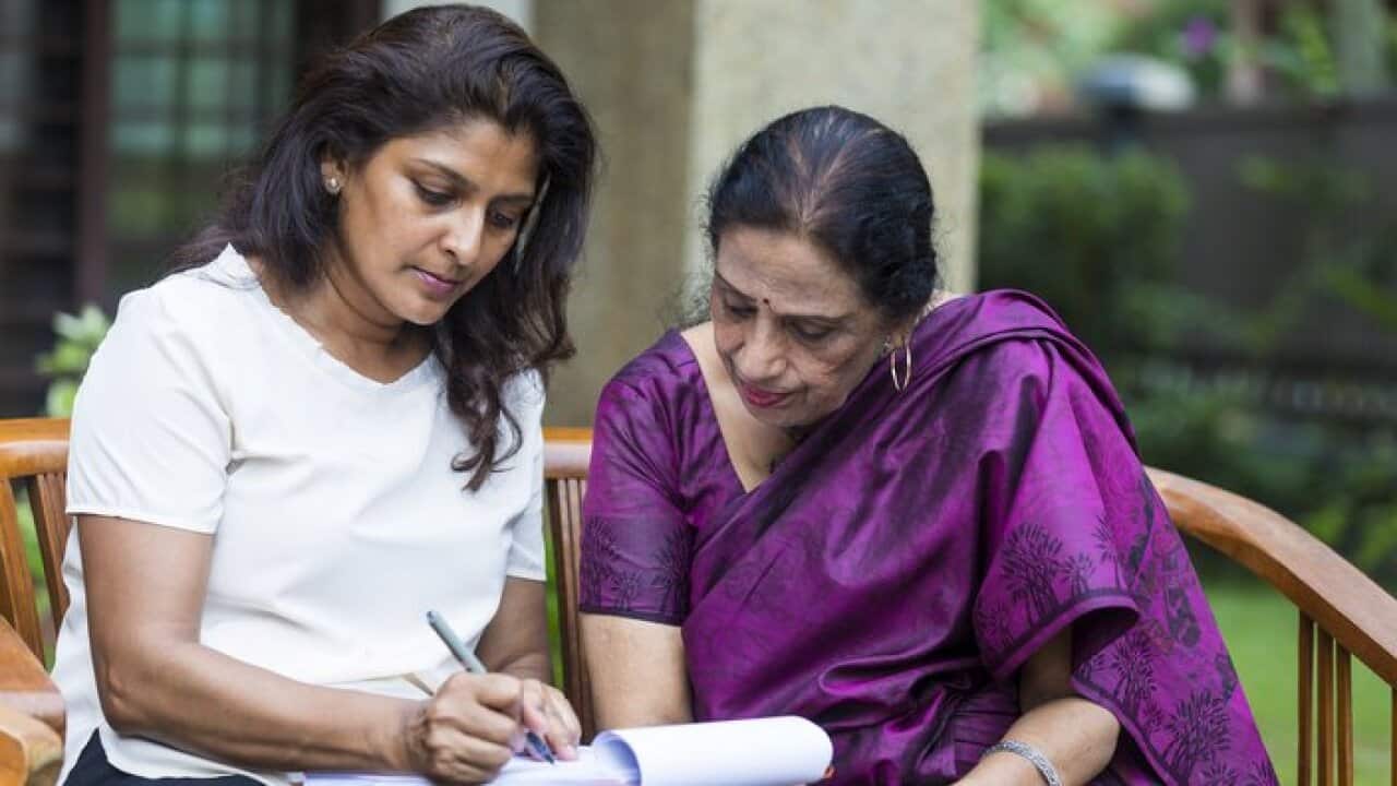 Leaning into the paper as the daughter fills up the last few sections of the document.