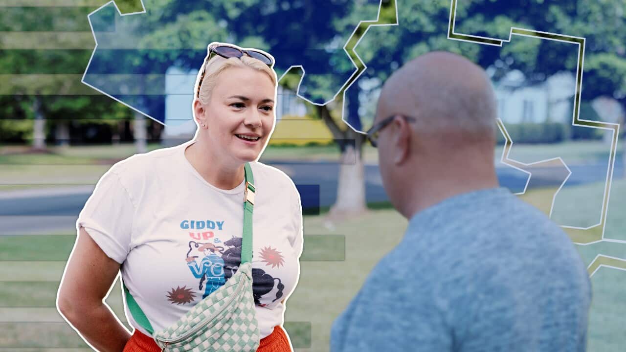 A woman speaks to a man.