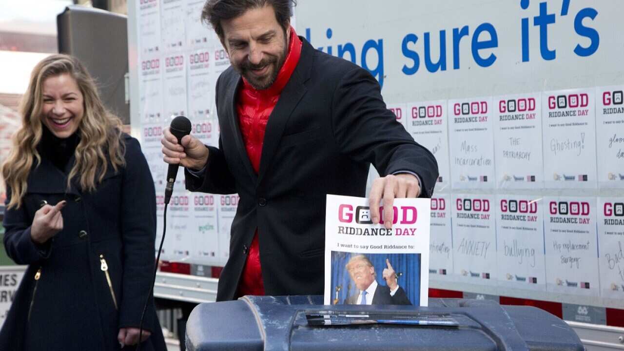 Tim Tompkins, president of the Times Square Alliance, shreds and forces a photo of Republican presidential candidate Donald Trump (AP Photo/Mark Lennihan)