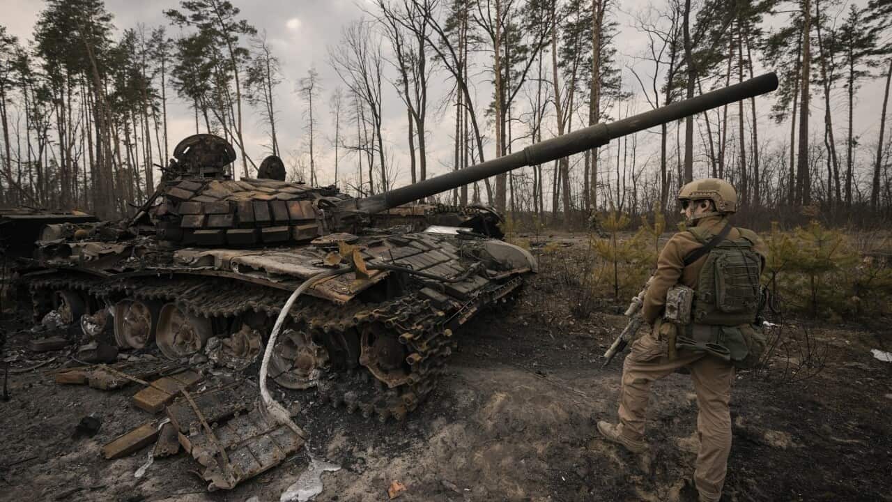 A Ukrainian serviceman stands next to a destroyed Russian tank after Ukrainian forces overran a Russian position outside Kyiv, Ukraine, on Thursday, 31 March, 2022.