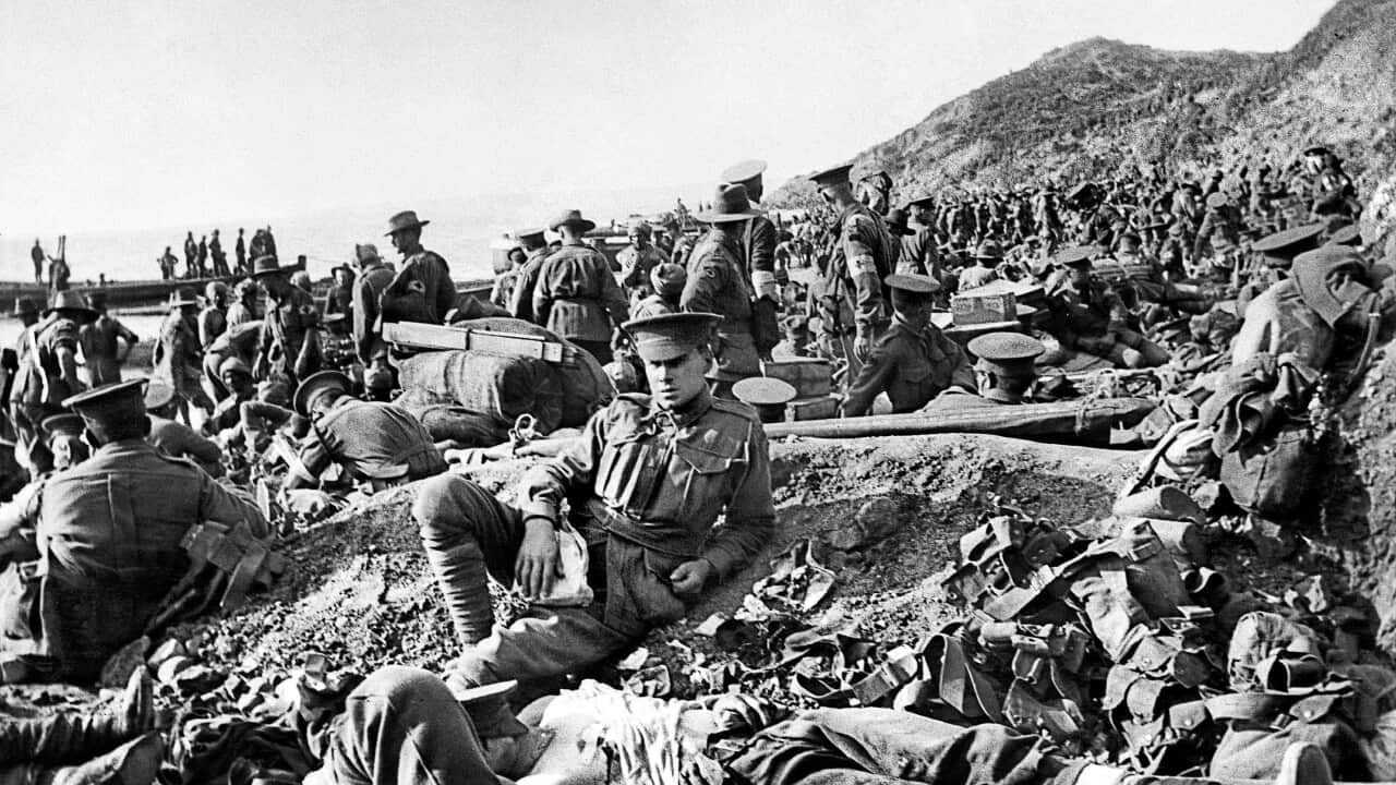An Australian soldier lies wounded, as other soldiers move on the beach at Anzac Cove on the day of the landing.