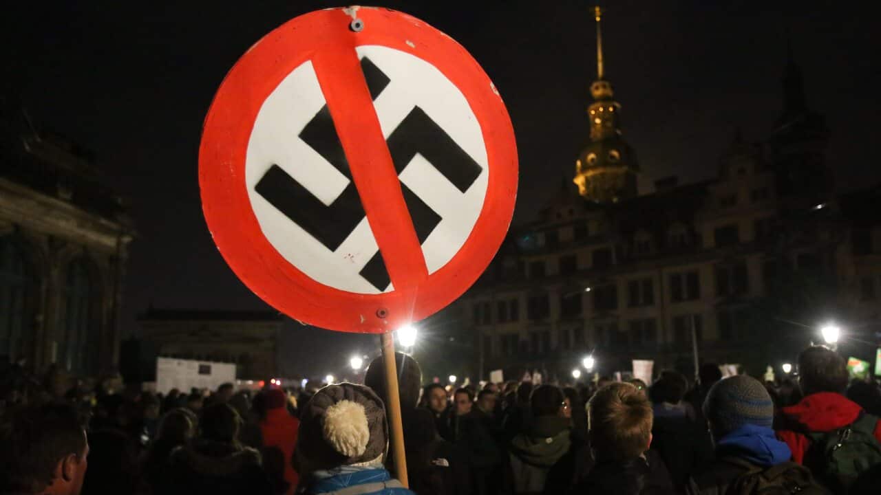 Anti-Fascism demonstrators carry a sign with a crossed-out swastika in Dresden, Germany. The Victorian opposition wants to ban the display of Nazi-era symbols. 