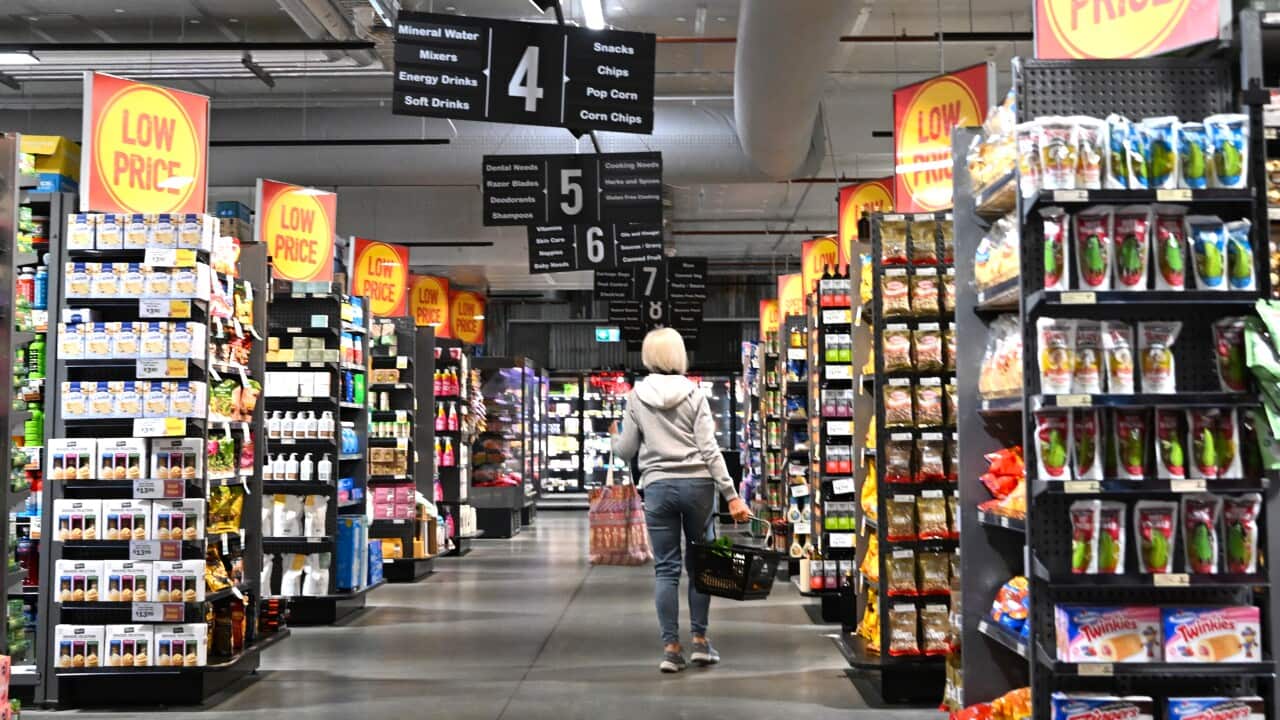 A woman in a supermarket aisle