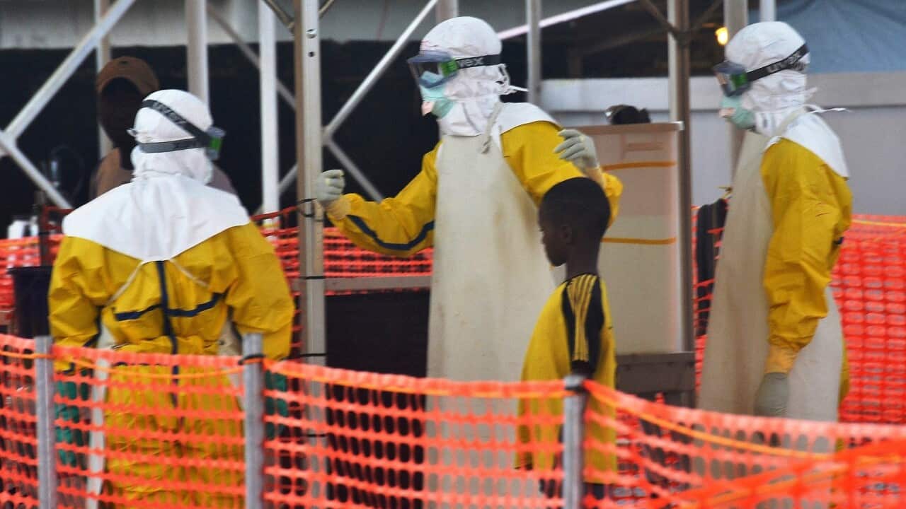 Health workers with a young patient under quarantine at an ebola treatment centre in Conakry, Guinea