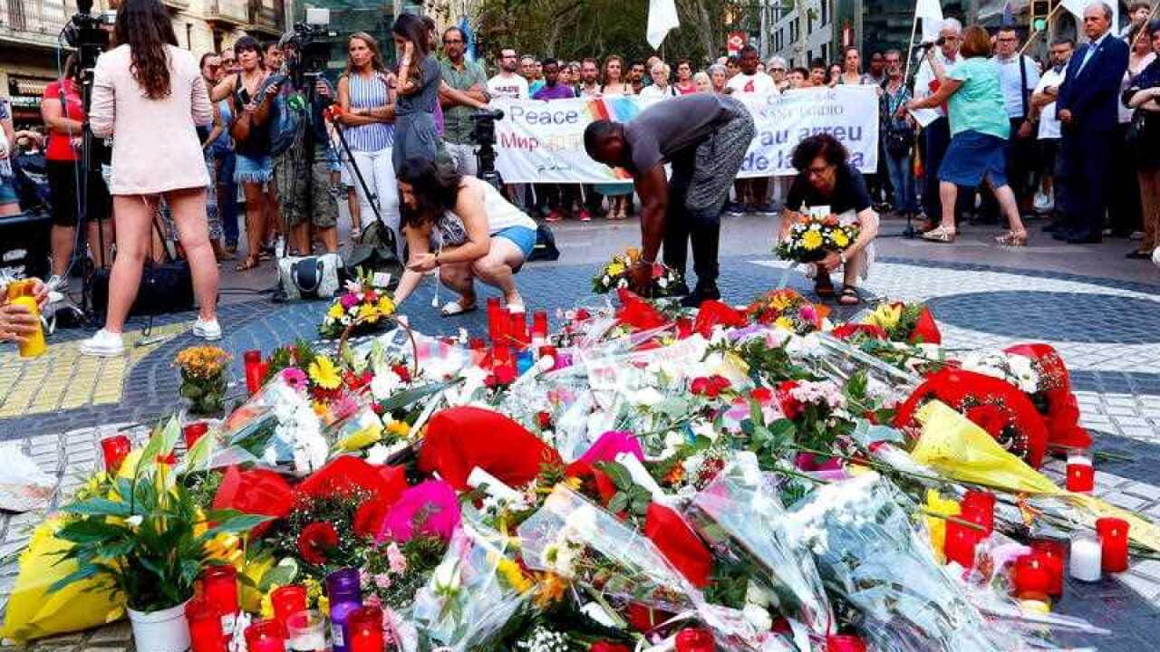 Mourners place flowers at a memorial during a ceremony held at Las Ramblas, Barcelona, north eastern Spain.