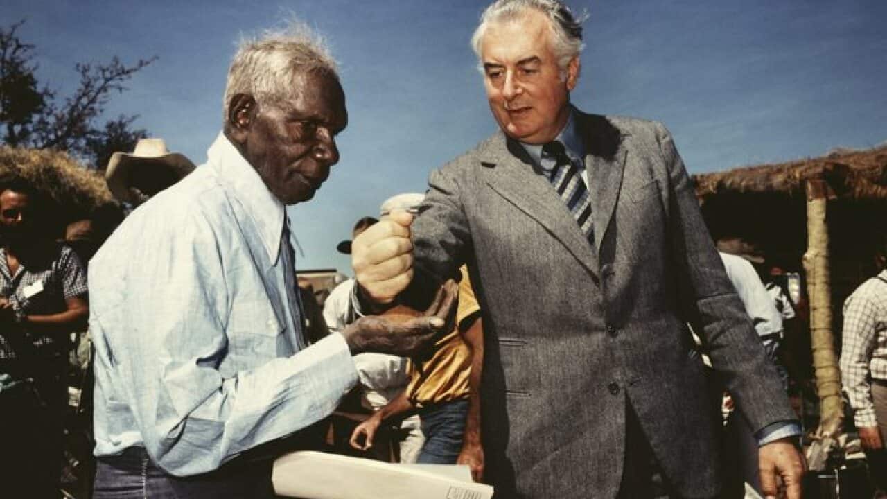 Mervyn Bishop, Prime Minister Gough Whitlam pours soil into the hands of traditional land owner Vincent Lingiari, Northern Territory (1975).