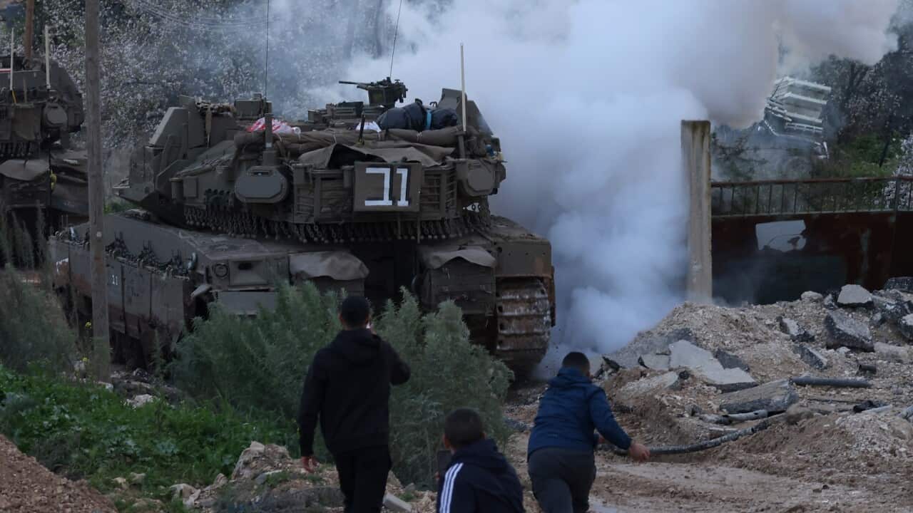 Palestinians throw stones as Israeli forces with tanks enter Jenin refugee camp (AAP).