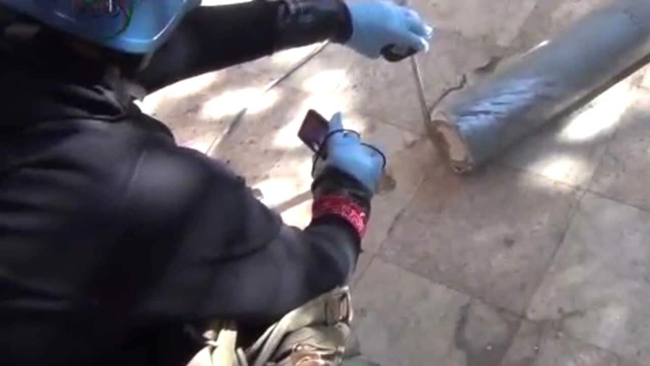 A UN staff member measuring a canister  in Damascus