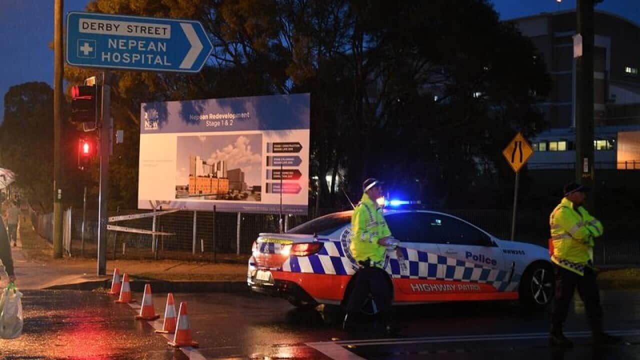 Police are seen manning roadblocks at the entrance to Nepean Hospital.