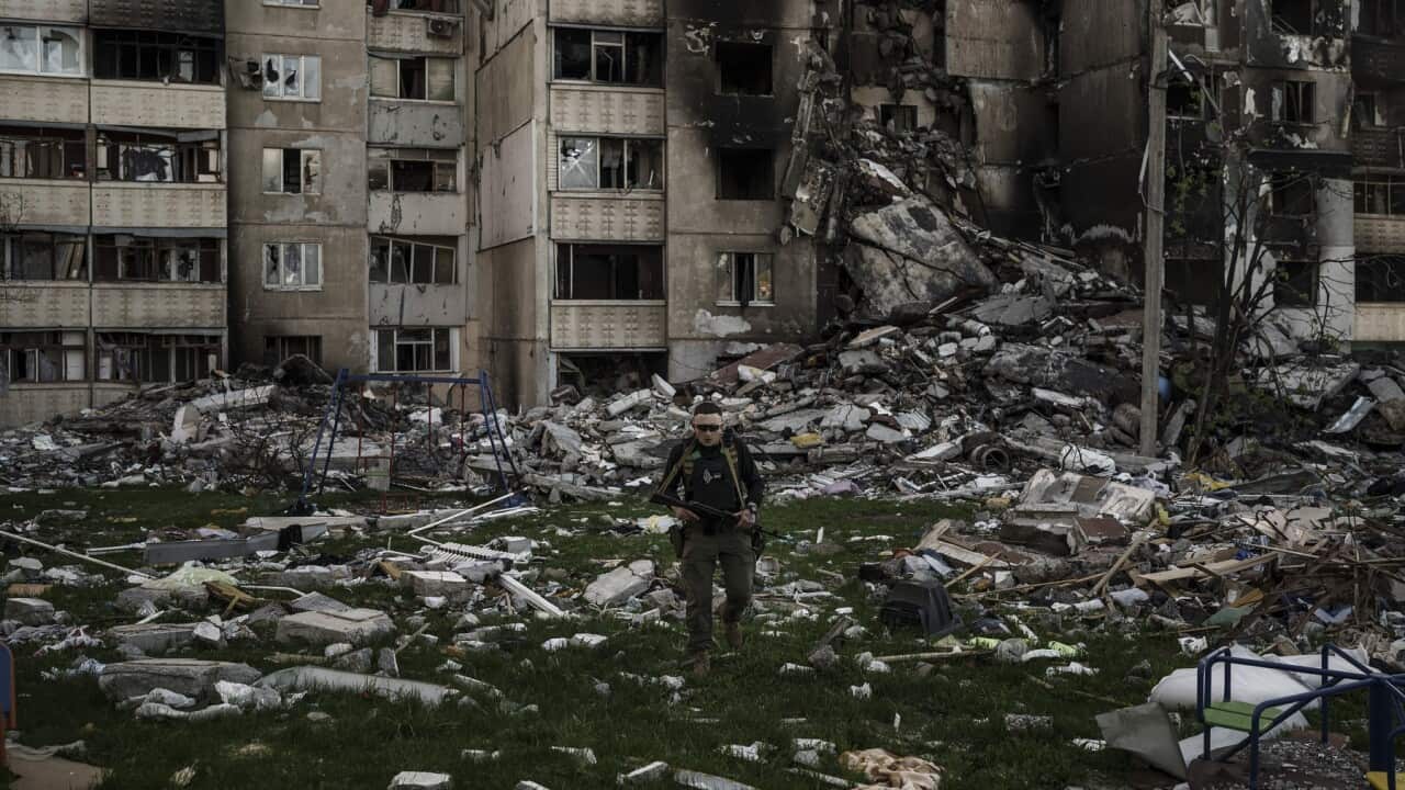 A Ukrainian serviceman amid the rubble of a building damaged by multiple Russian bombardments in Kharkiv