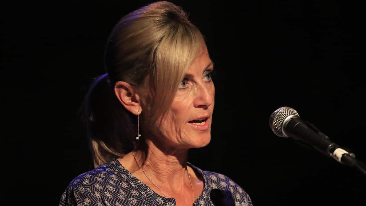A woman speaking in front of a microphone.