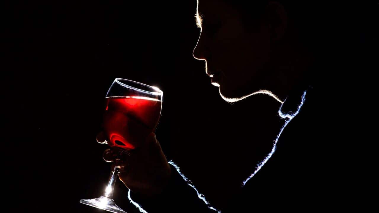 A woman drinking glass of red wine