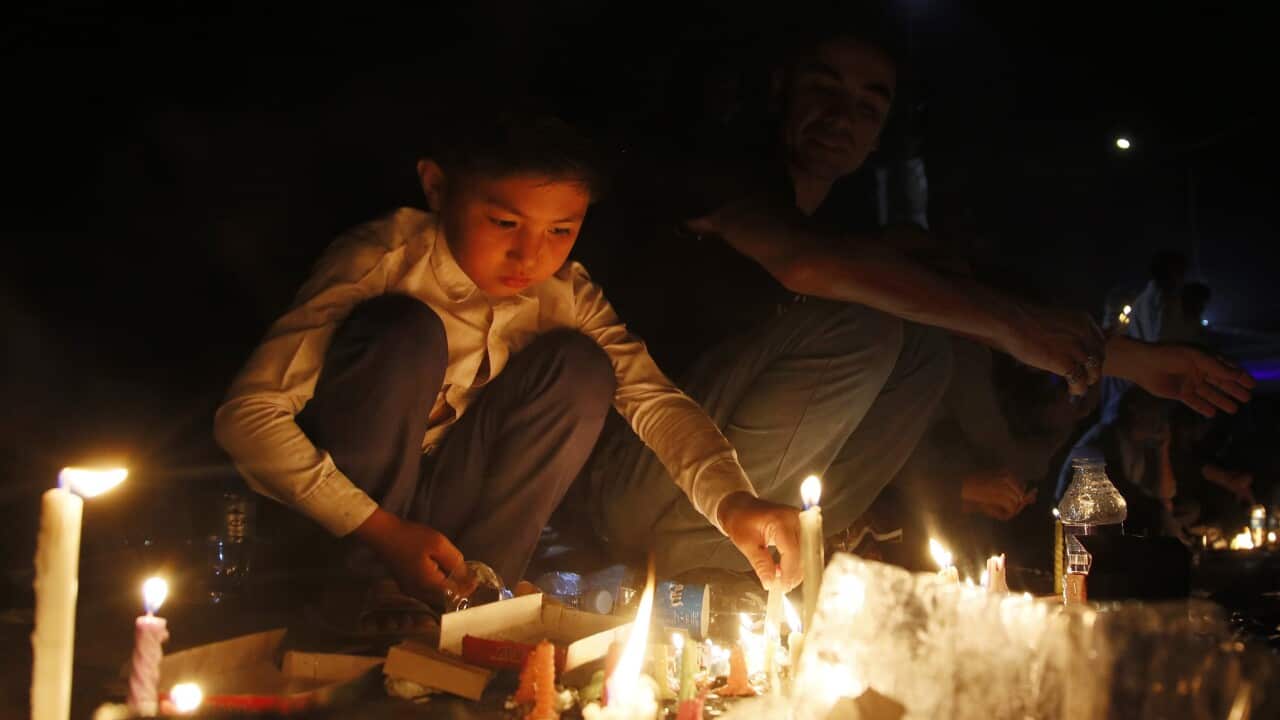 Afghans light candles during a memorial for the victims of a suicide bomb blast in Kabul.