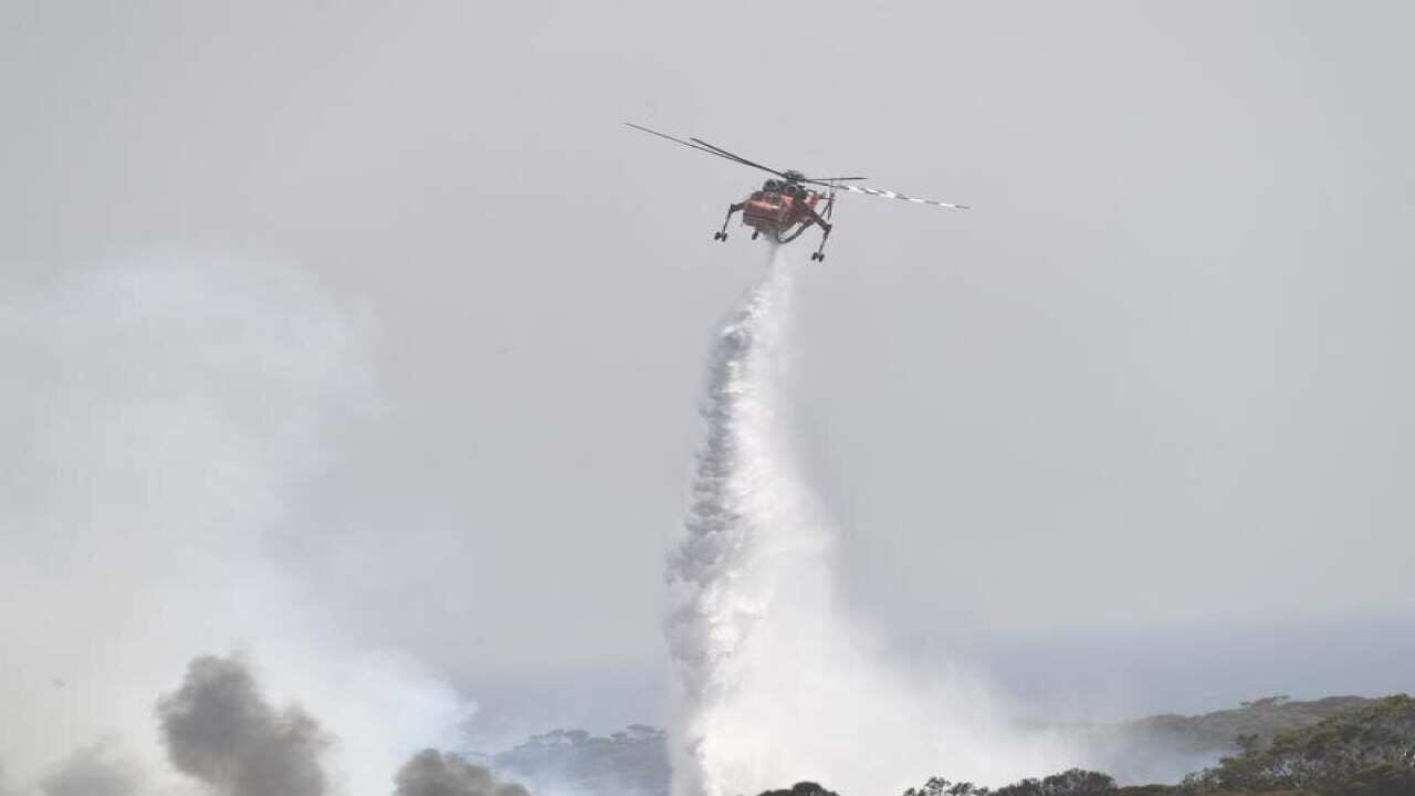 A helicopter dropping water on a bushfire on Kangaroo Island.