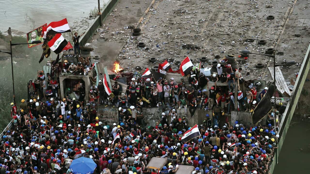 Anti-government protesters control some barriers set by Iraqi security forces to close the bridge leading to the Green Zone during ongoing protests in Baghdad