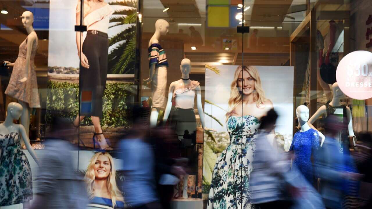 Pedestrians walk past a window display