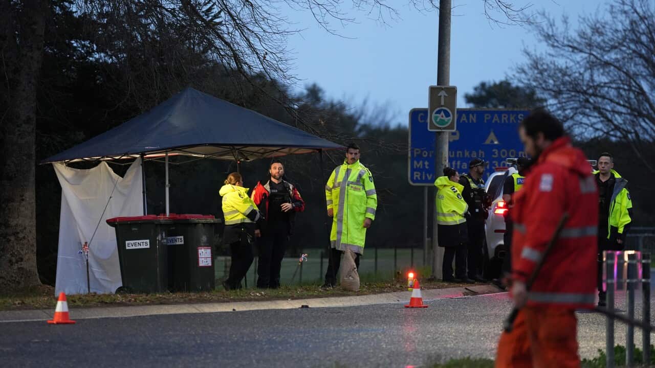 Police standing together at a crime scene.