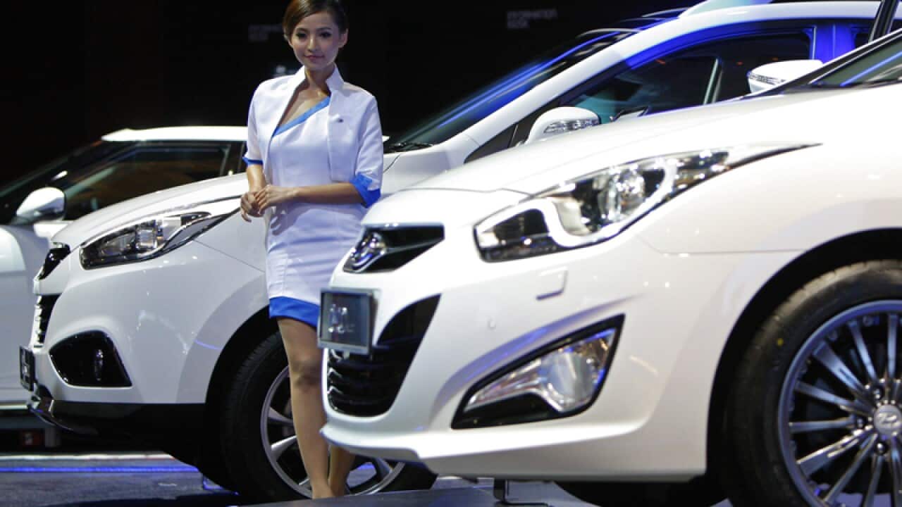 A model poses next to a Hyundai Tucson facelift on display