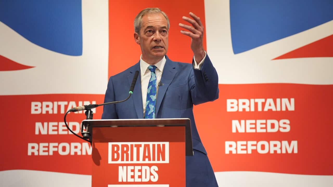 A man standing in front of the UK flag