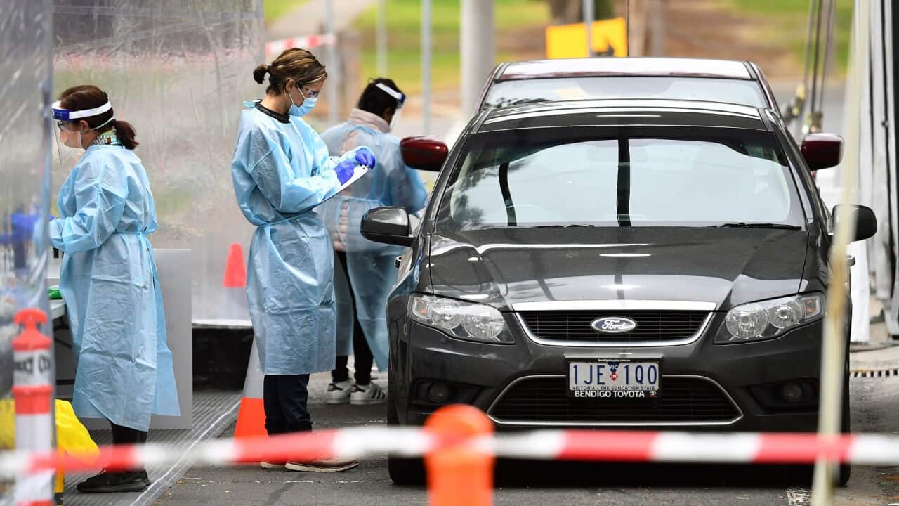 Medical staff prepare to take a swab at a drive-through testing clinic in Melbourne