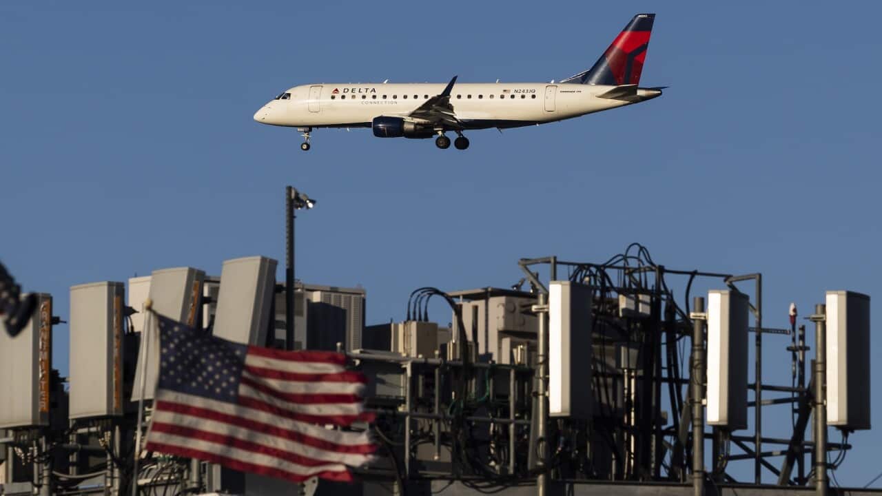 A plane landing in New York passes telecommunications antennae on a rooftop (AAP).