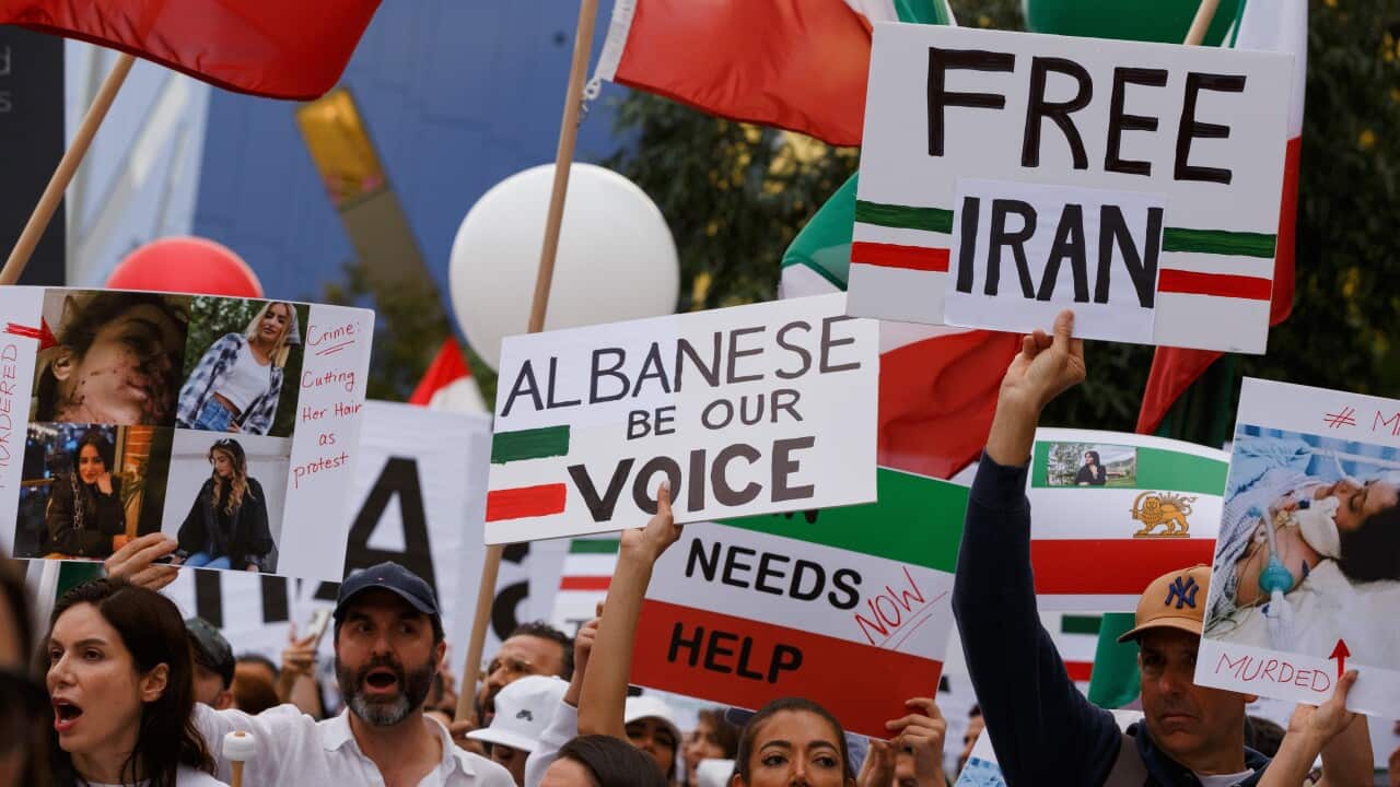 Protestors in Australia march with Iranian flags and in the centre of placards is one that reads "Albanese be our voice."