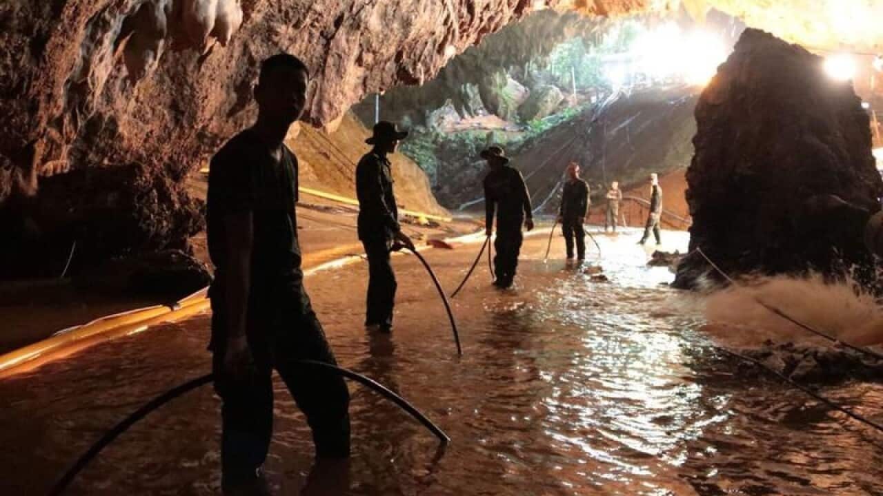 Thai rescue teams lay pipes to pump water out of the caves