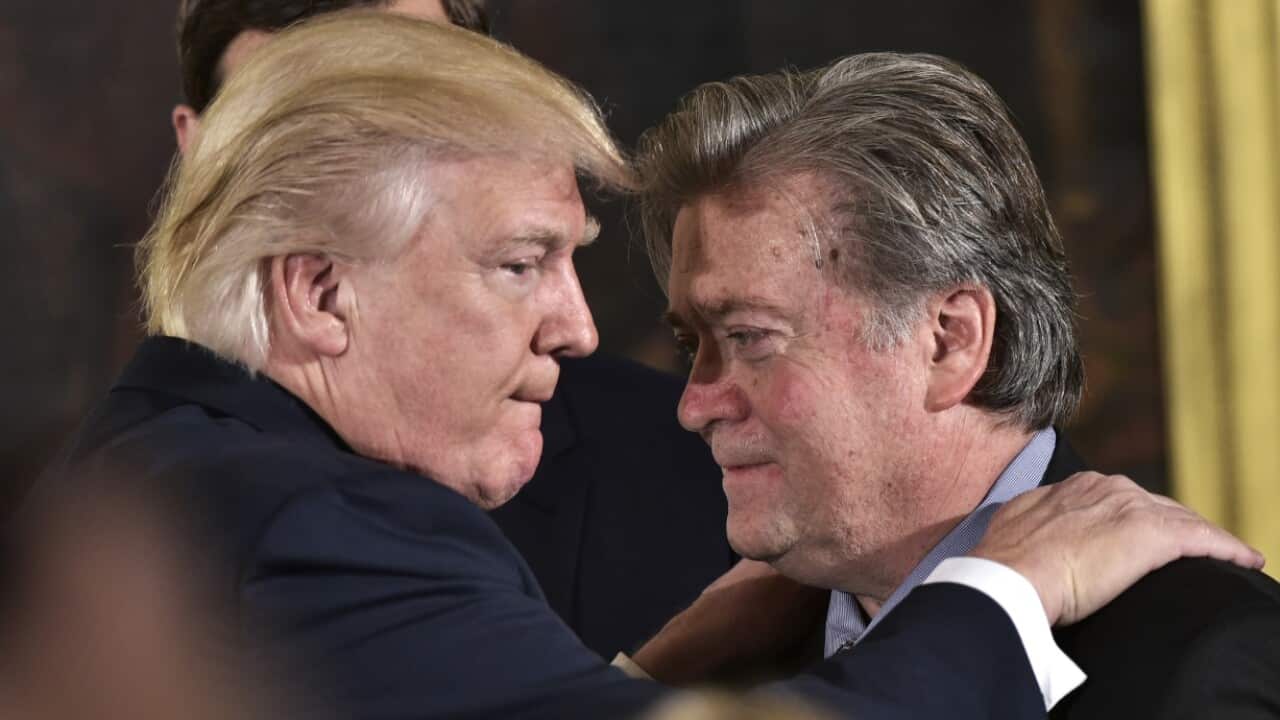 US President Donald Trump (L) congratulates Senior Counselor to the President Stephen Bannon during the swearing-in of senior staff in January 2017