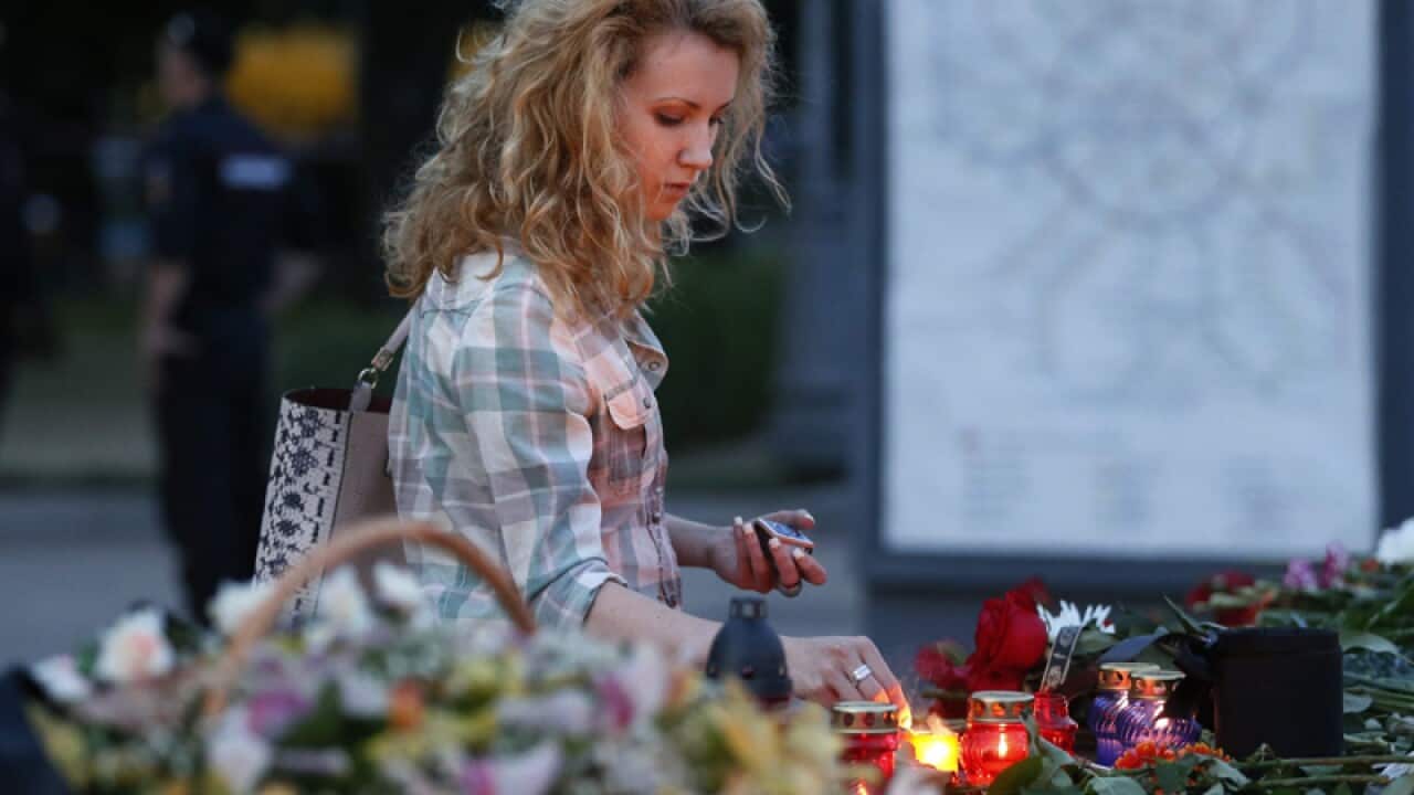 Woman lays flowers at memorial site for Moscow Metro Accident.