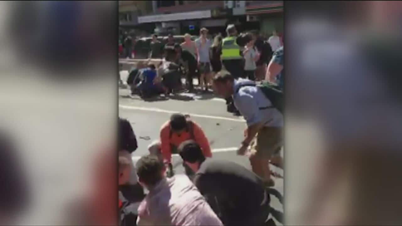 Pedestrians scramble to help after an SUV rammed into people on Flinders Street in Melbourne injuring 19.