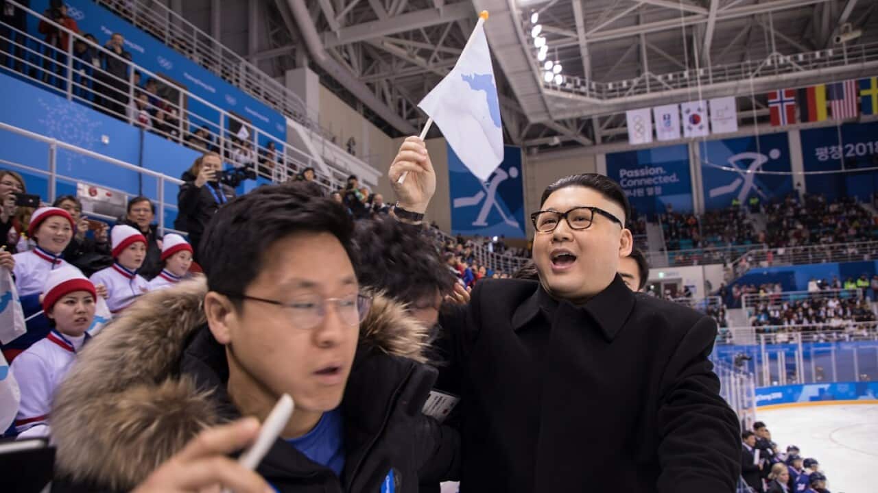 South Korean security guards remove a man impersonating North Korean leader Kim Jong-un as he waves a unified Korean flag.