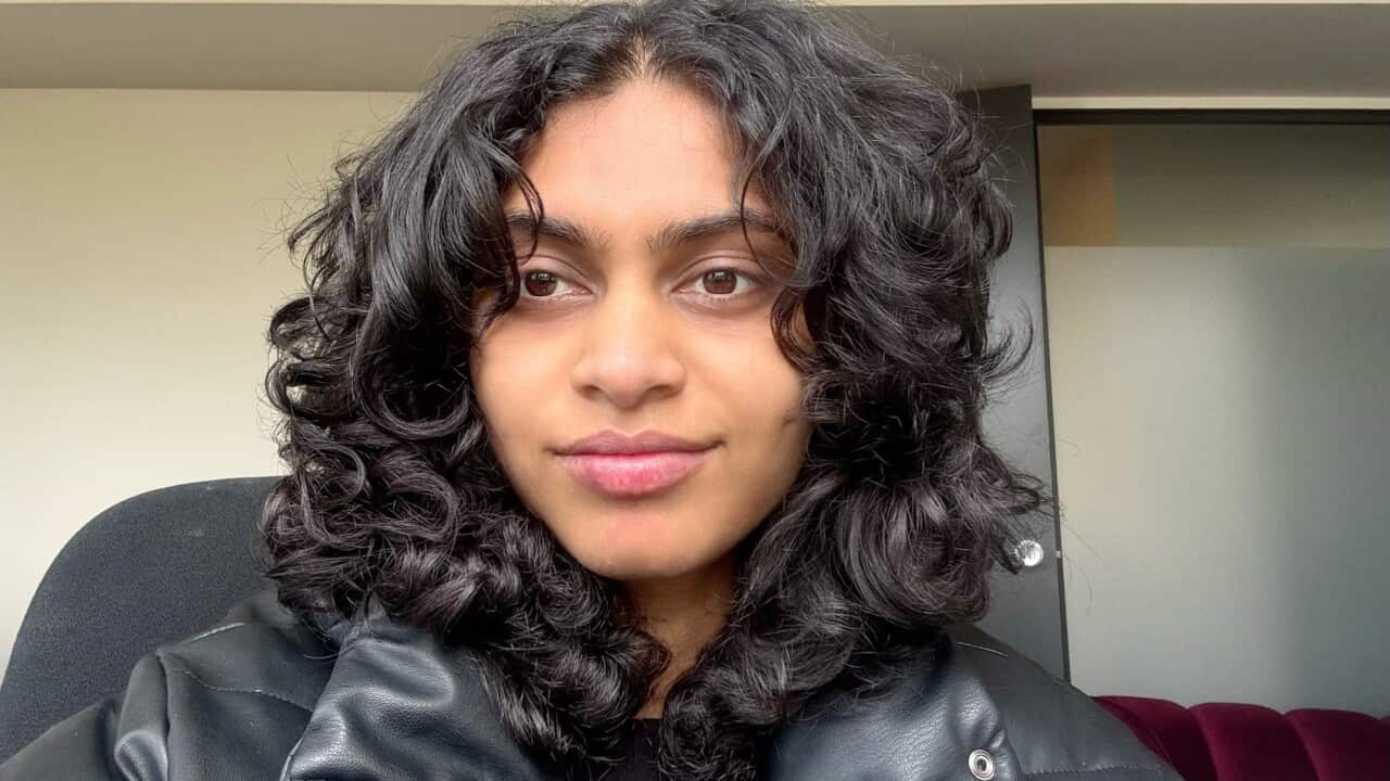 A head-and-shoulders shot of a woman in a black leather jacket looking at the camera with a slight smile on her face.