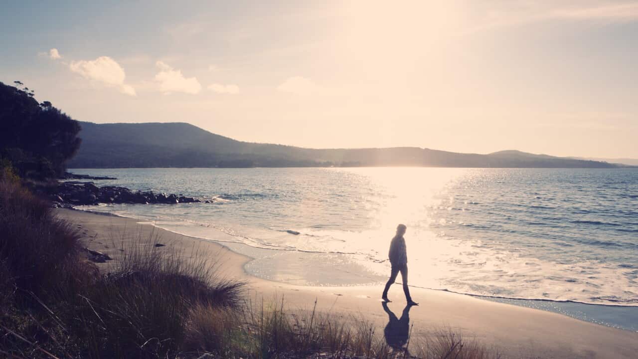 Woman taking sunset walk on beach