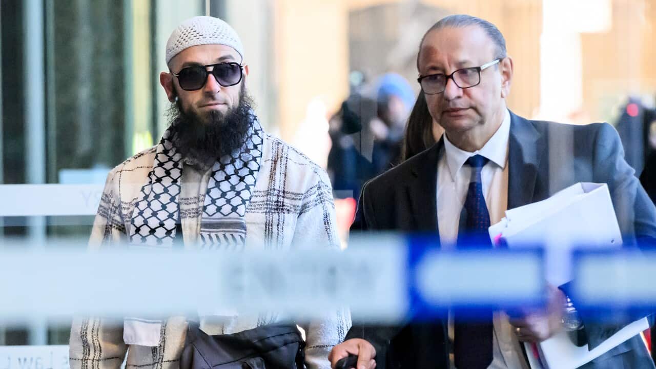 Two men walking through a door into a building.