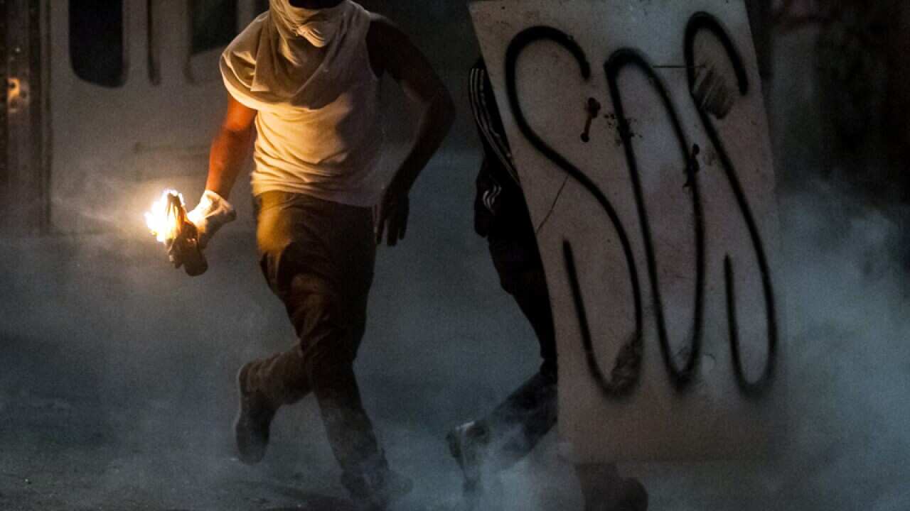 Demonstrators clash with the police during a protest in Caracas