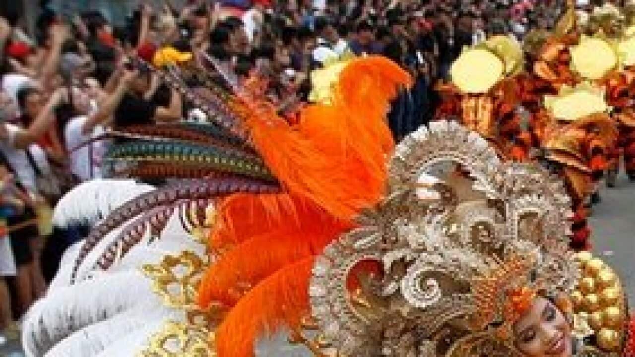 Filipino dancers in colourful costume hold statues of the Santo Nino (Child Jesus) as they perform during the 'Sinulog' Grand Parade in Cebu City, Philippines