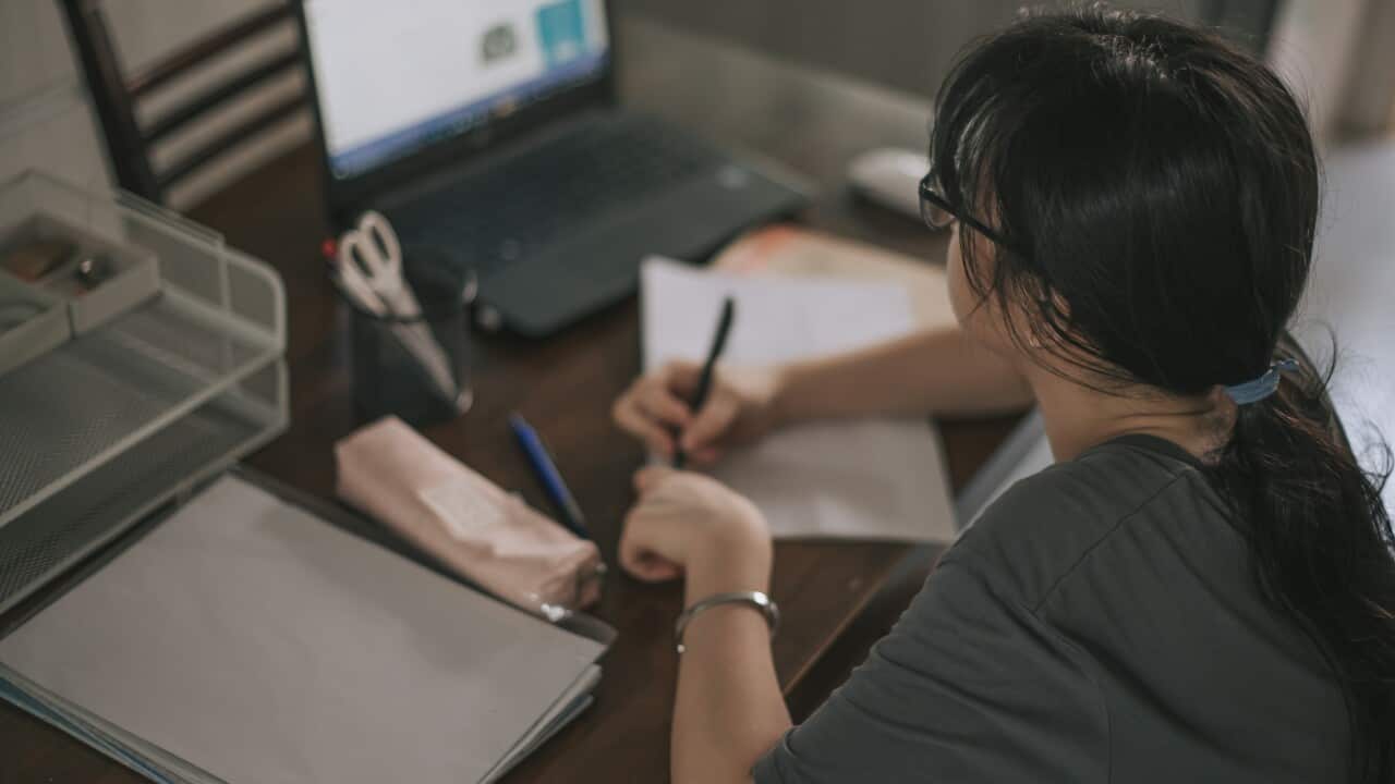 A teenage girl studying at her desk.