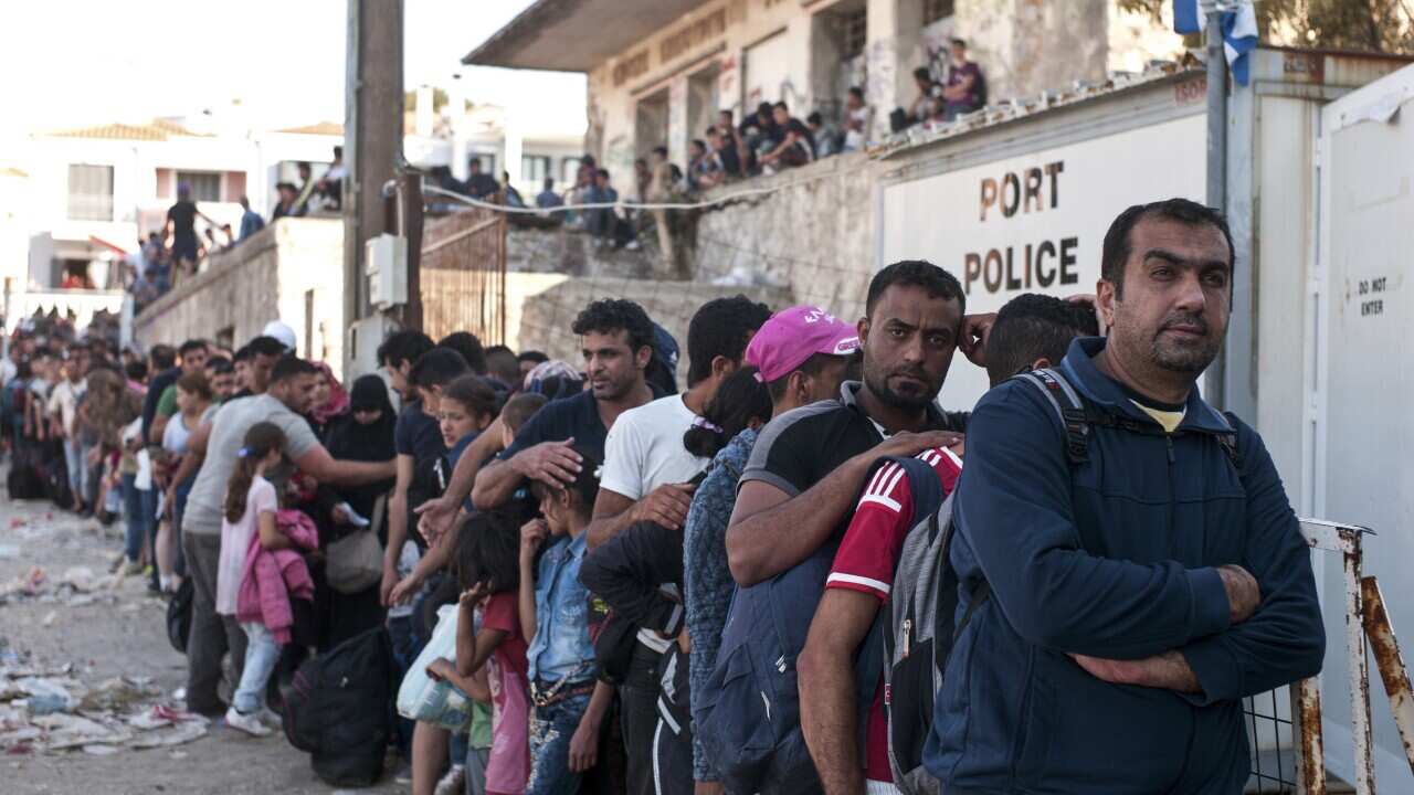 Migrants and refugees line up as they wait for a registration procedure at the port of northeastern Greek island of Lesbos, Greece, Saturday, Sept. 5, 2015. (AP Photo/Angelos Christofilopoulos)