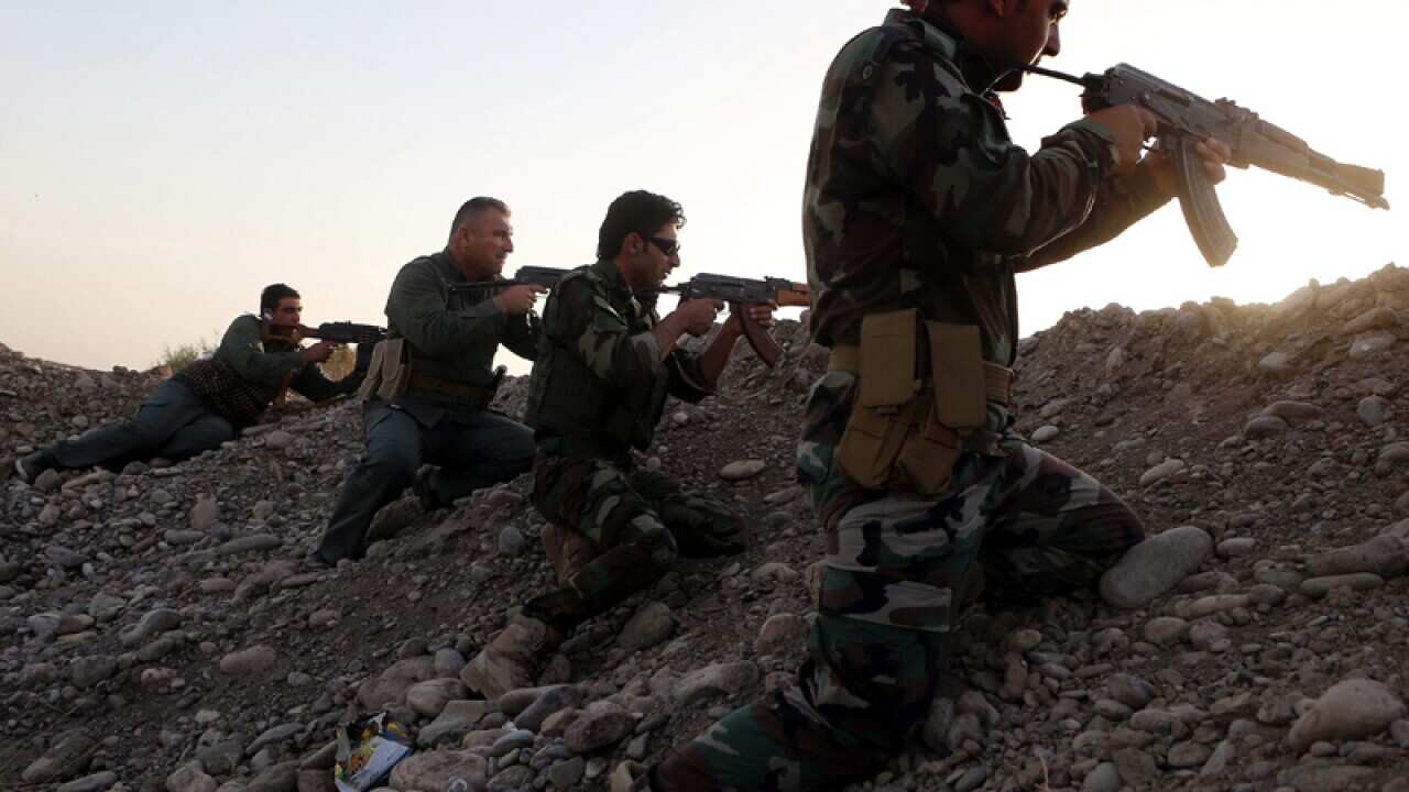 Iraqi Kurdish Peshmerga fighters take up positions