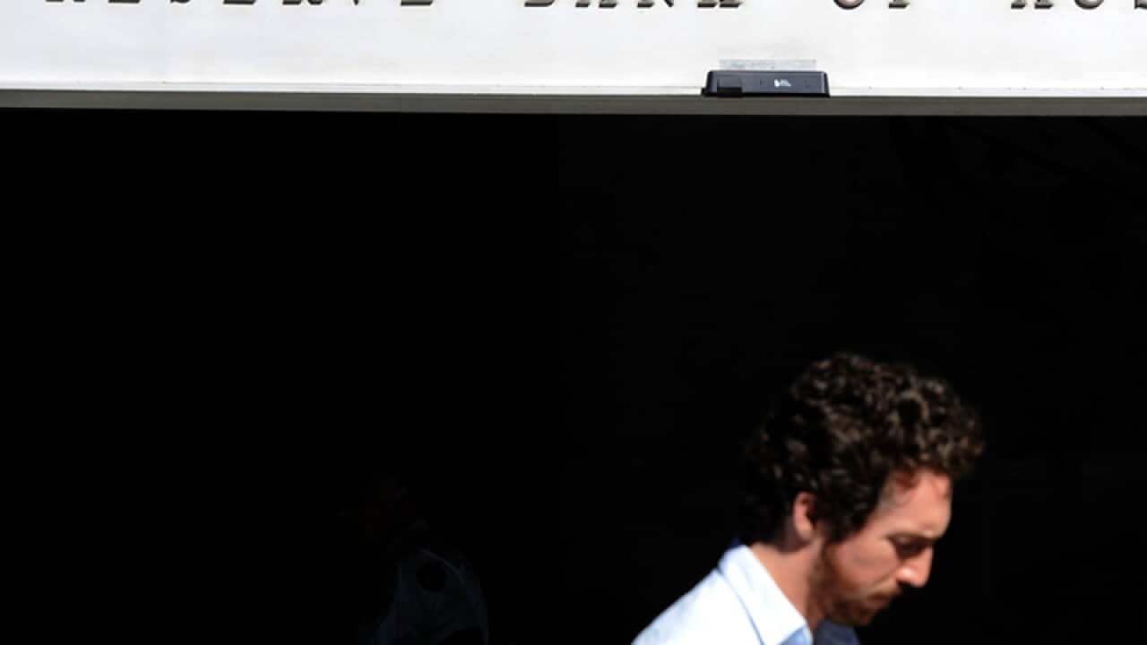 A man walks past RBA signage in Sydney