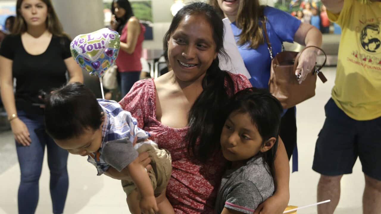 Buena Ventura Martin-Godinez holds her son Pedro as she and her daughter are reunited.