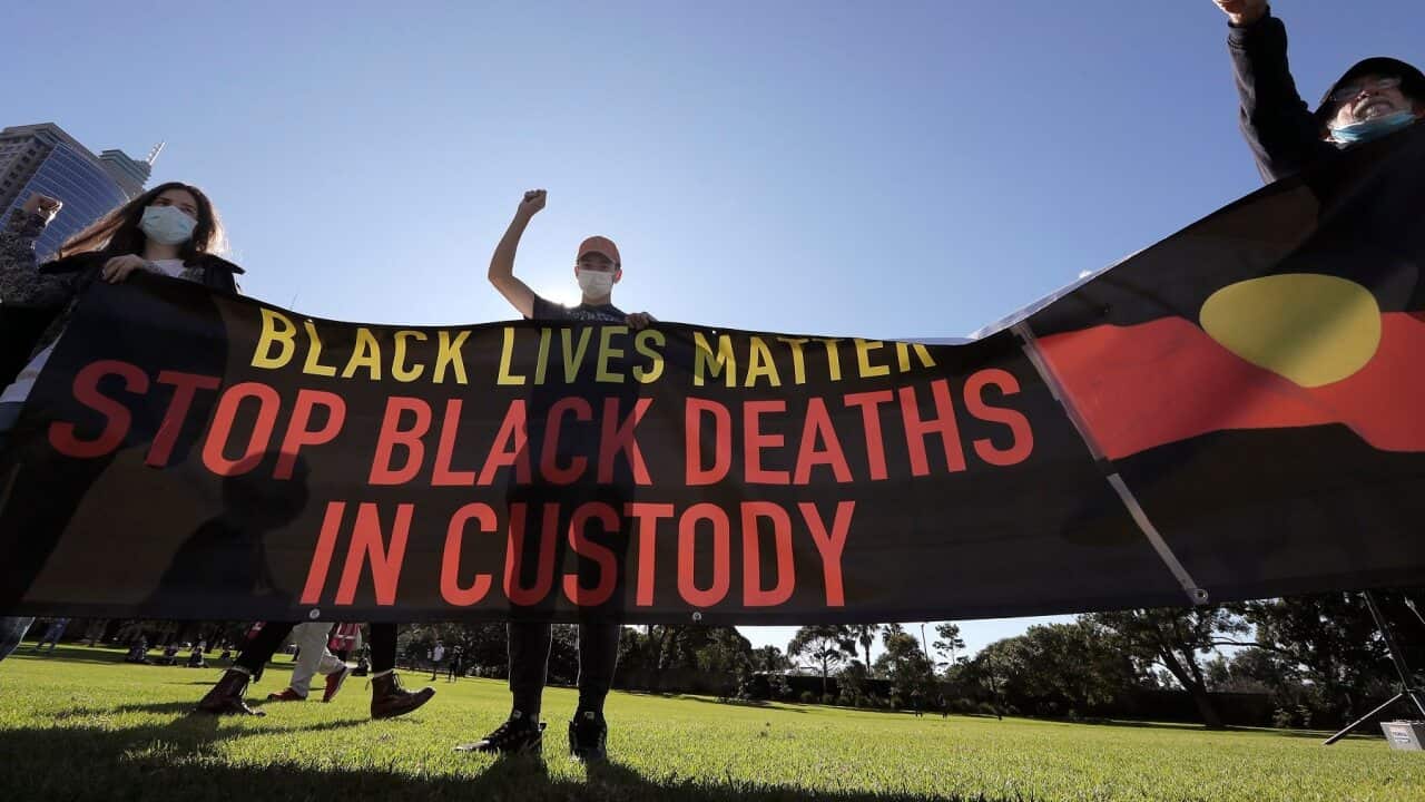 People hold a banner as thousands gather at a rally supporting the Black Lives Matter and Black Deaths in Custody movements in Sydney, Sunday, July 5, 2020. (AP Photo/Rick Rycroft)