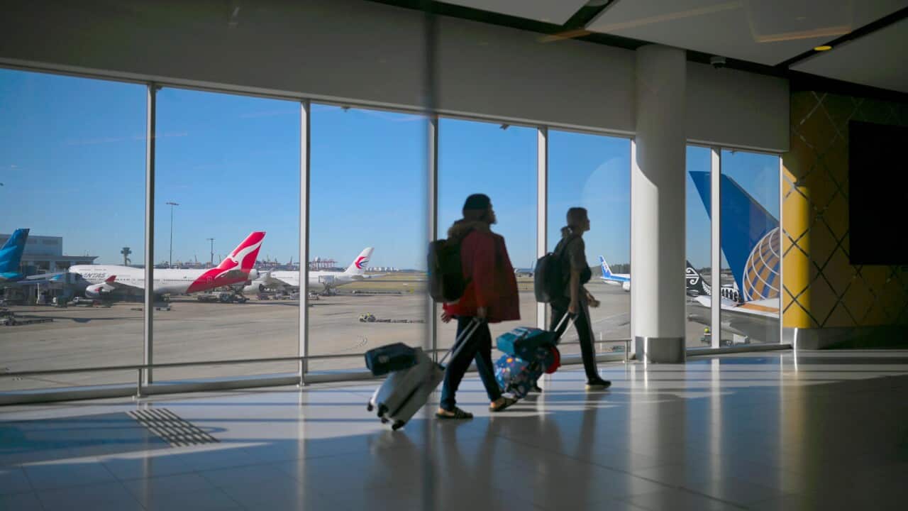 A Qantas plane is seen as passengers walk to their flights at Sydney International Airport in Sydney, Wednesday, August 21, 2019. (AAP Image/Lukas Coch) NO ARCHIVING